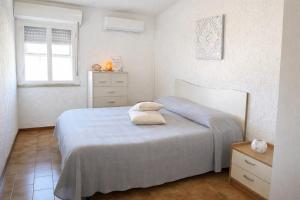 a bedroom with a blue bed and a window at Domo e Mare in Valledoria