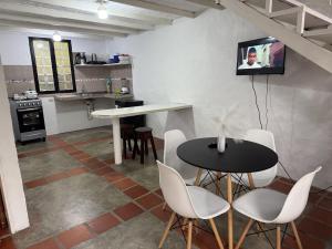 a kitchen with a table and chairs and a tv on the wall at Cabaña destino 11 in Mérida