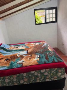 a bed in a room with a painting of a fox at Cabaña destino 11 in Mérida
