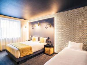 a hotel room with two beds and a window at Mercure Arras Centre Gare in Arras +100 photos