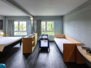 a room with two beds and a desk and two windows at ibis Saint Dizier in Saint-Dizier +121 photos