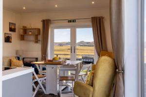 a kitchen and living room with a table and chairs at Green Law - Dog Friendly in Penicuik