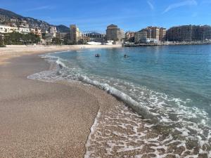 a beach with people swimming in the water at Casa Mediterraneo - Vue mer 3 min de la plage à pieds in Cap d'Ail +11 photos