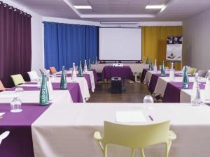 a conference room with tables and chairs and a screen at Hotel Mercure Kourou Ariatel in Kourou +67 photos