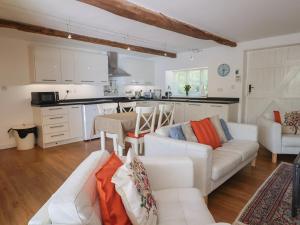 a living room with white furniture and a kitchen at Pottery Barn in Branscombe