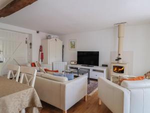 a living room with white furniture and a fireplace at Pottery Barn in Branscombe