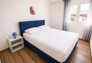 a bed with a blue headboard in a bedroom at Mia Apartment in Veles