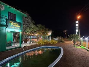 a swimming pool in front of a building at night at Hotel Popular in Pântano Grande +5 photos