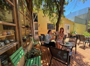 two women sitting at a table on a patio at Escarabajo Hostel in Valparaíso