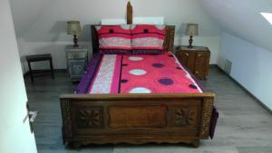 um quarto com uma cama de madeira e um edredão vermelho em Chez Tripp em Talmontiers