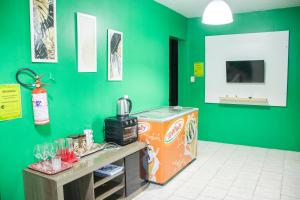 a room with a green wall with a counter and a food at Hotel Popular in Pântano Grande