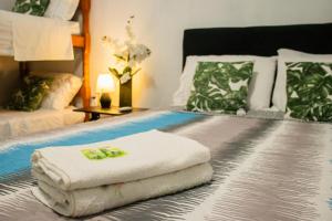 a bed with two towels sitting on top of it at Hotel Popular in Pântano Grande
