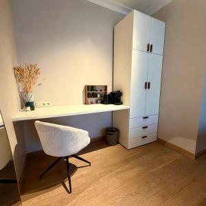 a white desk and a chair in a room at La Petite Suite - Unique Guesthouse in Schilde