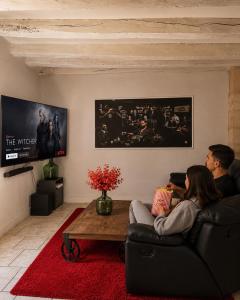 a man and woman sitting on a couch in a living room at PopCorn&Netflix in Bourges