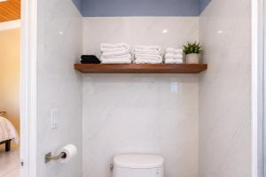 a bathroom with a toilet and towels on a shelf at Southside Serenity of St Croix in Christiansted +7 photos
