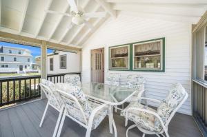 a dining room with a table and chairs on a porch at Les Bon Temps in Birch Town +11 photos