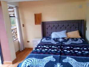 a bedroom with a bed with two zebras on it at Hatun Apu Center Casa de Ayahuasca y San Pedro in Pisac