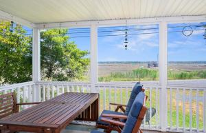 a screened in porch with a wooden table and chairs at Lighthouse Overlook in Birch Town