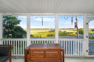 a screened in porch with a table and a view of the ocean at Lighthouse Overlook in Birch Town