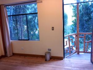 a room with two large windows and a balcony at Hatun Apu Center Casa de Ayahuasca y San Pedro in Pisac