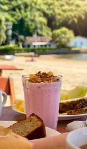 a drink with a piece of bread and a plate of food at Geko Pousada Paraty in Paraty +54 photos