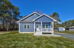a small blue house on a grass field at Lily Pad 2 in Birch Town