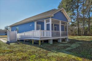 a blue tiny house with a porch and a gate at Lily Pad 2 in Birch Town +21 photos