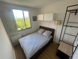 a small bedroom with a bed and a window at Magnifique appartement à Fréjus in Fréjus
