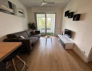 a living room with a couch and a table at Magnifique appartement à Fréjus in Fréjus