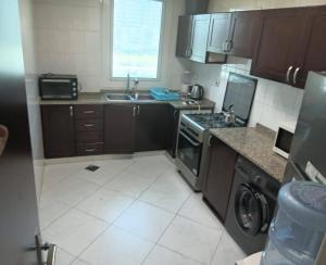 a small kitchen with a stove and a sink at Relaxing bed Ajman in Ajman 