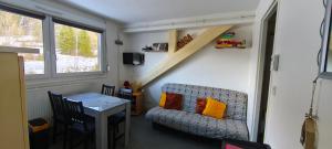 a room with a chair and a table and a staircase at Evasion Gérardmer in Gérardmer