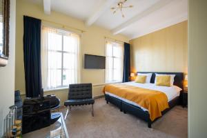 a bedroom with a bed and a flat screen tv at Herberg In de Valk in Middelstum
