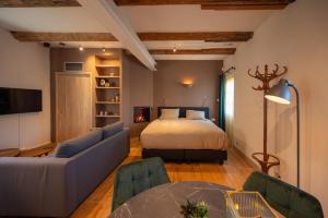 a bedroom with a bed and a couch and a table at Herberg In de Valk in Middelstum