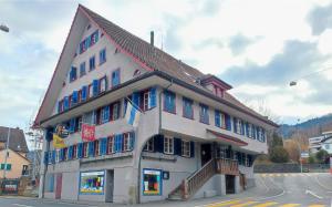 a large building with blue shuttered windows on a street at Klösterli Malters in Malters