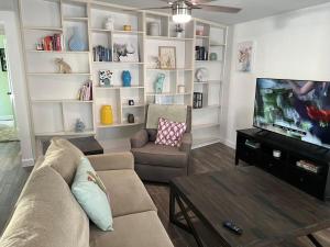 a living room with a couch and a tv at Artsy Oasis in Clearwater in Clearwater