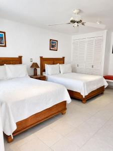 a bedroom with two beds with white sheets at Nuevo Amanecer in Tepoztlán