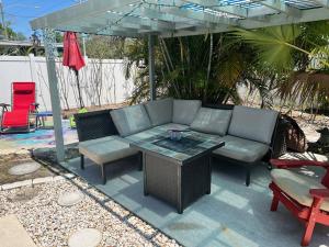 a patio with a couch and a table under an umbrella at Artsy Oasis in Clearwater in Clearwater