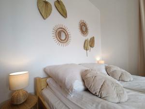 a bed with white sheets and leaves on the wall at Apartament Dwa Słońca in Gliczarów