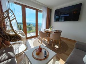 a living room with a table and chairs and a large window at Apartament Dwa Słońca in Gliczarów