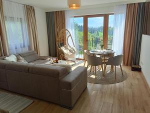 a living room with a couch and a table at Apartament Dwa Słońca in Gliczarów +9 photos