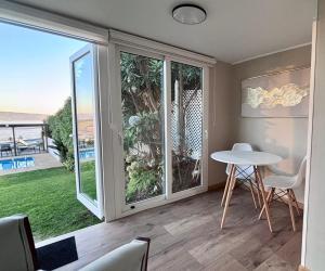 a room with a table and chairs and a large window at Hotel Camino del Alto Reñaca in Viña del Mar
