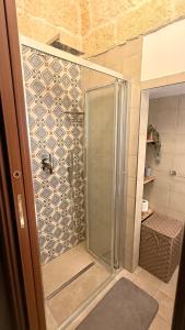 a shower with a glass door in a bathroom at Luxury Vittoria in Ceglie Messapica