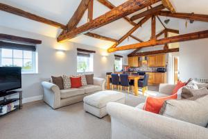 a living room with couches and a tv at Carleton Mill Cottage in Carlisle