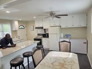 a man sitting at a counter in a kitchen at Beach Vacation Home in Rochester +35 photos