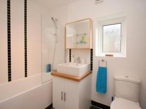 a white bathroom with a sink and a toilet at Home Vibes in Hornchurch