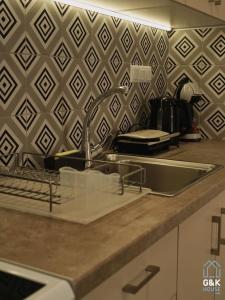 a kitchen counter with a sink and a wall at G&K House View in Messini