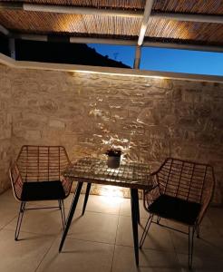 a table and two chairs in front of a stone wall at Lux Studios With Private Pool by ILIOS Georgioupoli in Georgioupoli