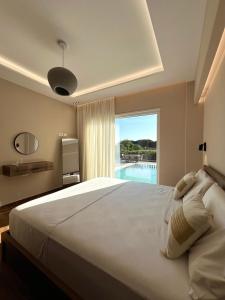 a bedroom with a large bed with a view of a pool at Sunset Aura Riverside Villa & Pool in Draç +64 photos