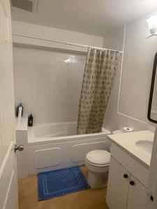 a bathroom with a tub and a toilet and a sink at Manor guesthouse in Vancouver