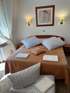 a bedroom with a large bed with two pillows at Pensjonat Perła in Pobierowo